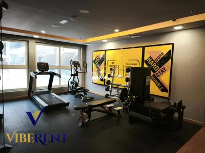 a gym with two treadmills and weights in a room at Modern 1BR Apartment with Pool & Gym, 15 Min to JBR in Dubai