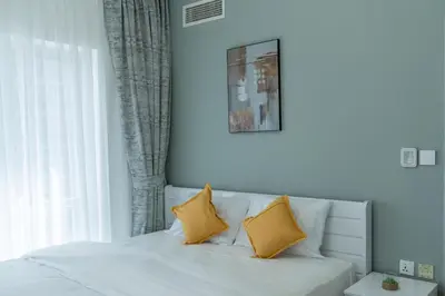 a white bed with two yellow pillows on it at Dubai Marina - 2BHK Luxurious Apartment in Dubai