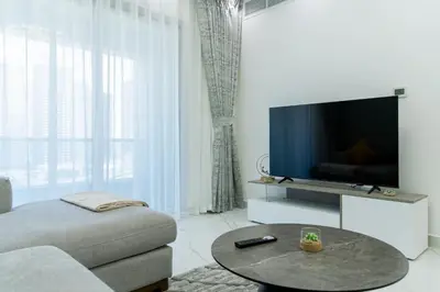 a living room with a tv and a couch and a table at Dubai Marina - 2BHK Luxurious Apartment in Dubai