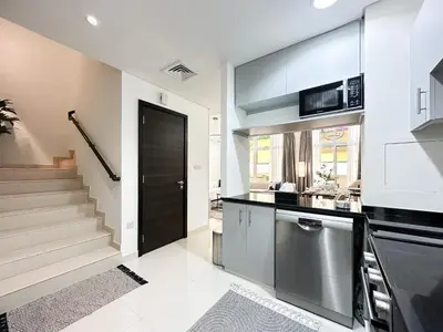 a kitchen with a staircase and a black door at Stylish 3BR Retreat Bright Interiors Townhouse Comfort in Dubai