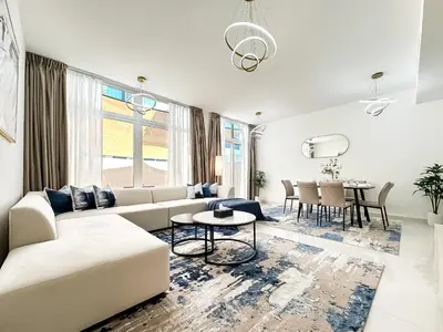 a white living room with a couch and a table at Stylish 3BR Retreat Bright Interiors Townhouse Comfort in Dubai