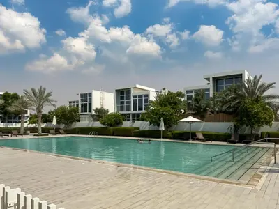 a swimming pool in front of some buildings at Stylish 3BR Retreat Bright Interiors Townhouse Comfort in Dubai