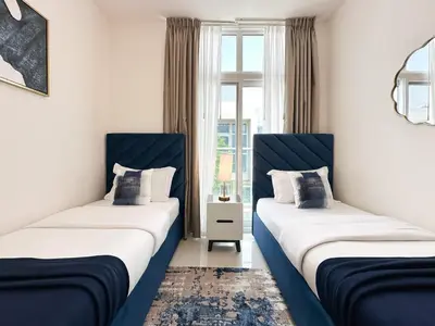 two beds in a room with blue and white at Stylish 3BR Retreat Bright Interiors Townhouse Comfort in Dubai