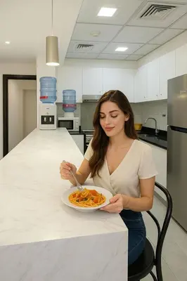 a woman sitting at a counter eating a plate of food at Luxury Private Capsule Room near Business Bay Downtown in Dubai