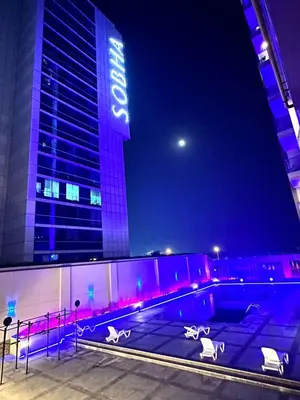 a swimming pool in front of a building at night at Luxury Private Capsule Room near Business Bay Downtown in Dubai