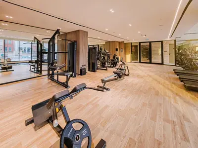 a gym with several treadmills and cardio machines at A Signature Living Experience Luxury One-Bedroom in Binghatti Emerald, JVC, Dubai in Dubai