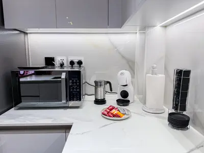 a kitchen with a microwave and a plate of food at A Signature Living Experience Luxury One-Bedroom in Binghatti Emerald, JVC, Dubai in Dubai