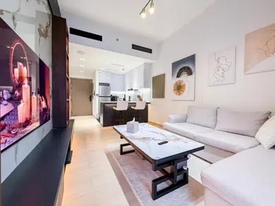 a living room with a white couch and a table at A Signature Living Experience Luxury One-Bedroom in Binghatti Emerald, JVC, Dubai in Dubai
