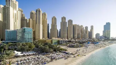 a beach with umbrellas and a city with tall buildings at MiamiDXB Full Sea View -2Bd apartment in Dubai