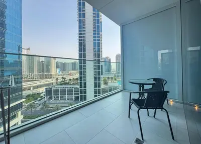 a balcony with a table and chair on a building at Spacious Studio Private Balcony Sea View in Dubai