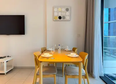 a dining room with a yellow table and chairs at Spacious Studio Private Balcony Sea View in Dubai