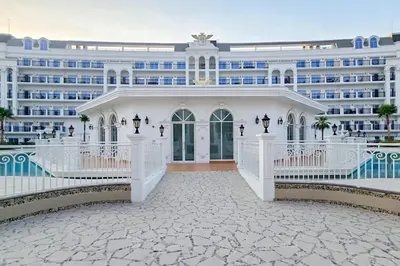 a large white building with a white fence at EasyGo- Luxury Living with Resort Facilities and Amenities in Dubai