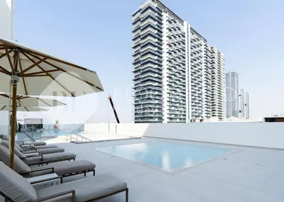 a swimming pool with chairs and a tall building at Bloomfields Cozy 1Br Binghatti House in Dubai