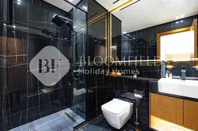 a black tiled bathroom with a toilet and a sink at Bloomfields Cozy 1Br Binghatti House in Dubai
