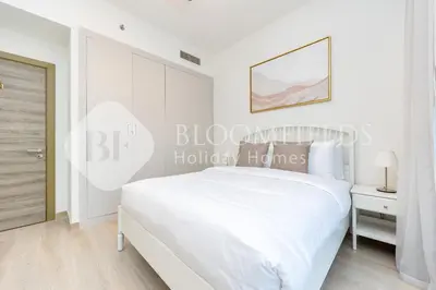 a white bedroom with a white bed and a door at Bloomfields Spacious 1br Bloom Tower in Dubai