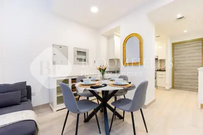 a white living room with a table and chairs at Bloomfields Spacious 1br Bloom Tower in Dubai
