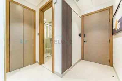 a corridor with wooden doors in a building at High Floor, Few Steps From Dubai Canal and Waterfront Promenade, Sobha Hartland Waves, Sobha Hartland by Deluxe Holiday Homes in Dubai