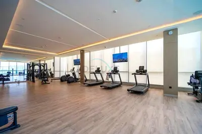 a gym with treadmills and exercise equipment in a building at High Floor, Few Steps From Dubai Canal and Waterfront Promenade, Sobha Hartland Waves, Sobha Hartland by Deluxe Holiday Homes in Dubai