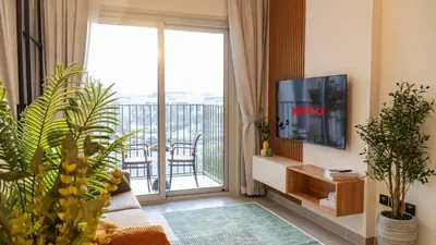 a living room with a tv and a balcony at New Luxury 1 Bed - Opposite Dubai Hills Mall in Dubai