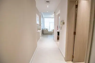 a hallway with white walls and a white floor at Canal-View one bedroom Apt Business Bay in Dubai