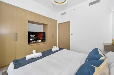 a bedroom with a large white bed with towels on it at Golden Stays - 5 Mins From Mall I Downtown Dream 1Br Apt in Dubai