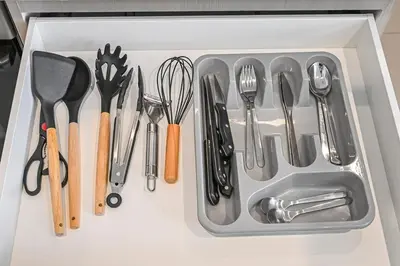 a drawer filled with utensils on a counter at Golden Stays - 5 Mins From Mall I Downtown Dream 1Br Apt in Dubai