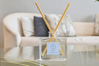 a glass bottle on a glass table with chop sticks in it at Golden Stays - 5 Mins From Mall I Downtown Dream 1Br Apt in Dubai