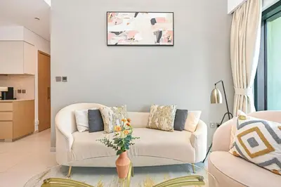 a living room with a couch and a table at Golden Stays - 5 Mins From Mall I Downtown Dream 1Br Apt in Dubai