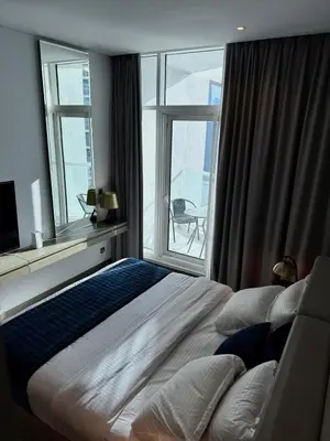 a bedroom with a large bed and a large window at Apartment In Downtown Dubai in Dubai