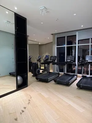 a gym with several treadmills and elliptical machines at Apartment In Downtown Dubai in Dubai