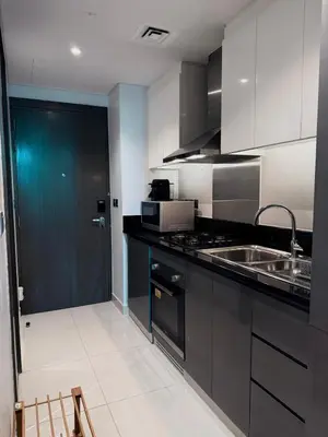 a kitchen with black and white cabinets and a sink at Apartment In Downtown Dubai in Dubai