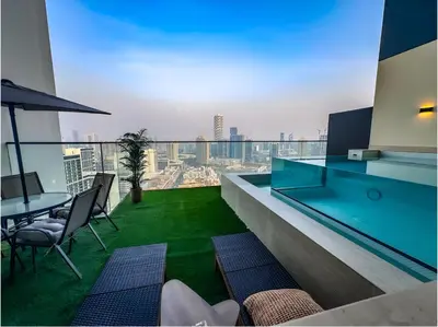 a balcony with a table and chairs in a building at Solysian Stay in Dubai