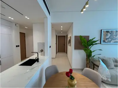 a kitchen and living room with a table and a counter at Solysian Stay in Dubai