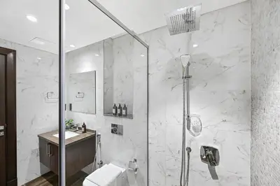 a bathroom with a shower and a toilet and a sink at Stylish Apartment with Balcony and Pool, Close to Dubai's Top Landmarks in Dubai