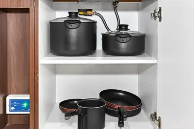 two pots and pans on a shelf in a kitchen at Stylish Apartment with Balcony and Pool, Close to Dubai's Top Landmarks in Dubai