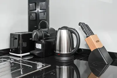 a coffee maker on a counter next to a microwave at Stylish Apartment with Balcony and Pool, Close to Dubai's Top Landmarks in Dubai