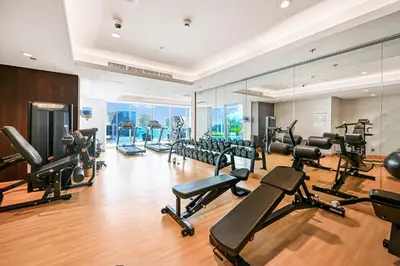 a gym with a lot of treadmills and machines at Stylish Apartment with Balcony and Pool, Close to Dubai's Top Landmarks in Dubai