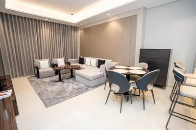 a living room with a couch and a table and chairs at Highlife Haven in Dubai with Pool and Gym in Dubai