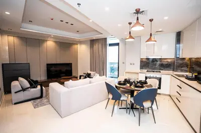 a living room with a white couch and a table at Luxe 1BR Suite Dubai Dream Stay with Pool and Gym in Dubai