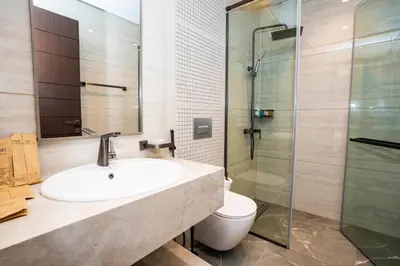 a bathroom with a sink and a toilet and a shower at Luxe 1BR Suite Dubai Dream Stay with Pool and Gym in Dubai