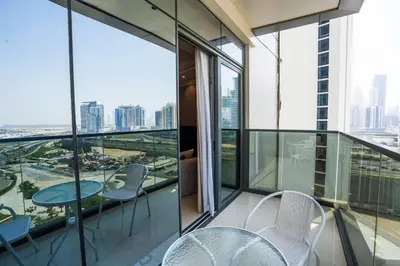 a balcony with chairs and tables and a view of the city at Luxe 1BR Suite Dubai Dream Stay with Pool and Gym in Dubai