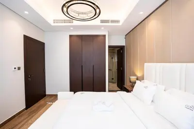 a bedroom with a large white bed with white pillows at Luxe 1BR Suite Dubai Dream Stay with Pool and Gym in Dubai