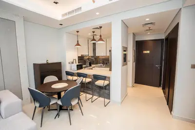 a kitchen and dining room with a table and chairs at Cityscape Retreat Nobles 2BR Nobles Edition in Dubai