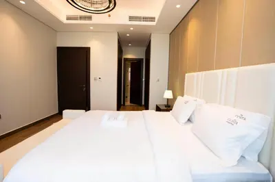 a bedroom with a large white bed with white pillows at Cityscape Retreat Nobles 2BR Nobles Edition in Dubai