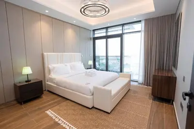 a bedroom with a white bed and a large window at Cityscape Retreat Nobles 2BR Nobles Edition in Dubai