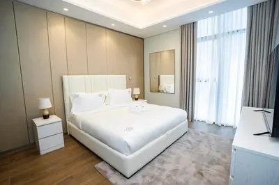 a bedroom with a large white bed and a television at Luxury 1BR in Nobles Tower Business Bay in Dubai