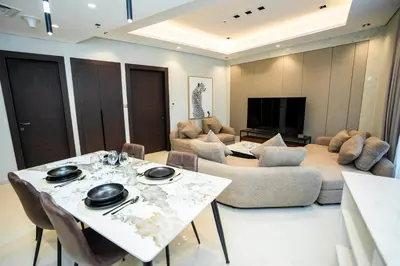 a living room with a couch and a table and chairs at Luxury 1BR in Nobles Tower Business Bay in Dubai