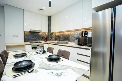 a kitchen with a table with black dishes on it at Luxury 1BR in Nobles Tower Business Bay in Dubai