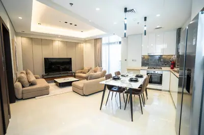 a kitchen and living room with a table and chairs at Luxury 1BR in Nobles Tower Business Bay in Dubai