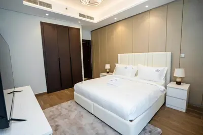 a bedroom with a large white bed and a television at Luxury 1BR in Nobles Tower Business Bay in Dubai